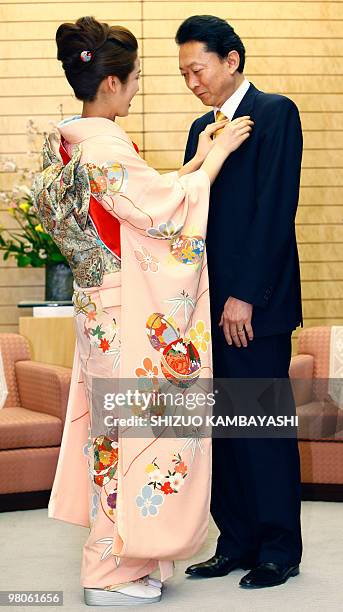 Japanese Prime Minister Yukio Hatoyama receives a badge from 2010 Miss Japan Grand Prix Mina Hayashi at Hatoyama's official residence in Tokyo on...