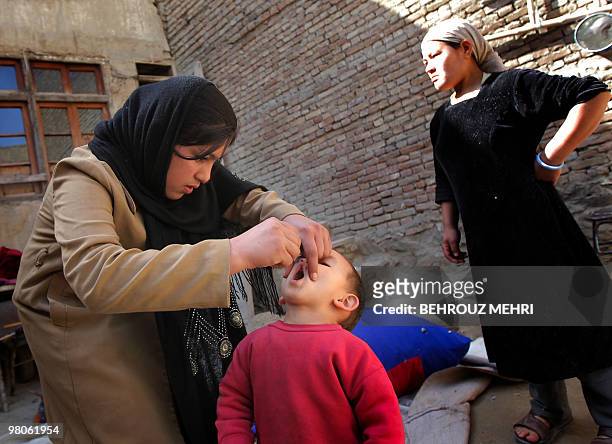 An Afghan health worker administers the polio vaccine to a child on the second day of a vaccination campaign in Kabul on March 15, 2010. A three-day...