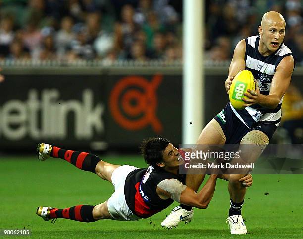 Gary Ablett of the Cats is tackled by Angus Monfries of the Bombers during the round one AFL match between the Geelong Cats and the Essendon Bombers...