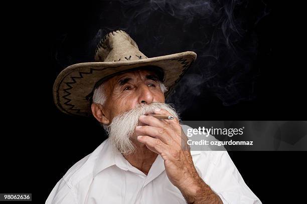 old cowboy smoking - ozgurdonmaz stock pictures, royalty-free photos & images