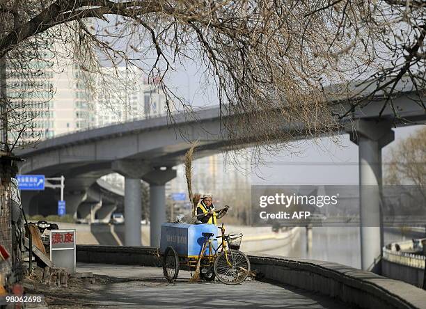 Street sweeper cleans along a lane in Beijing on March 16, 2010. Following 30 years of explosive growth, China is on track to overtake Japan as the...