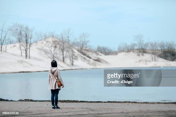 rear view of woman enjoying the beautiful scenics and the tranquility by the pond at sand banks - los alfaques location fotografías e imágenes de stock