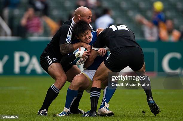 Chen Cheng-Yang of Chinese Taipei is tackled by DJ Forbes and Zar Lawrence of New Zealand on day one of the IRB Hong Kong Sevens on March 26, 2010 in...