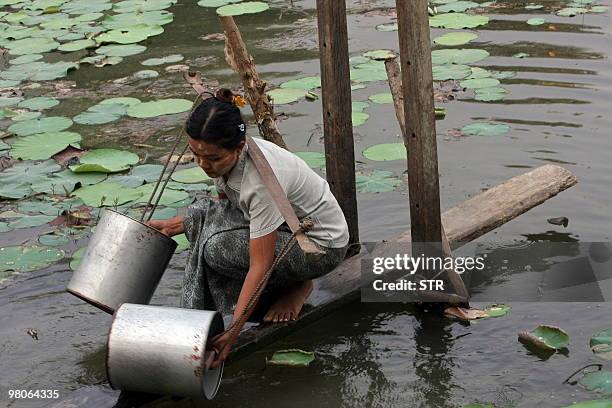 Photo taken on March 17, 2010 shows a Myanmar woman collecting water from a pond in a village near Yangon. As the world marks the UN-sponsored World...