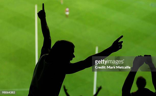 Geelong fans celebrate a goal scored during the round one AFL match between the Geelong Cats and the Essendon Bombers at Melbourne Cricket Ground on...