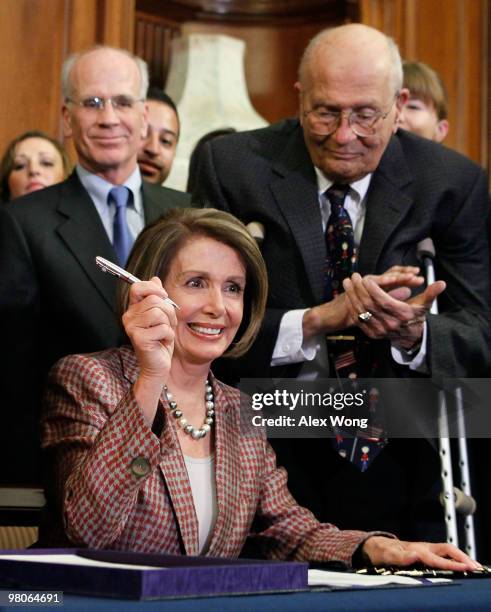 Speaker of the House Rep. Nancy Pelosi signs the revised Health Care and Education Reconciliation Act during an enrollment ceremony as Rep. John...