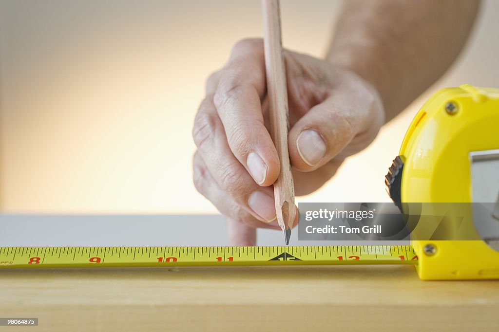 Measuring with measuring tape and pencil