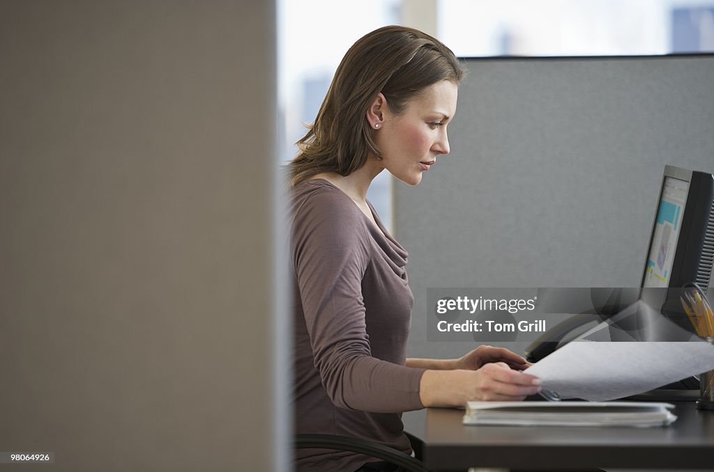 Woman working on computer in office cubicle