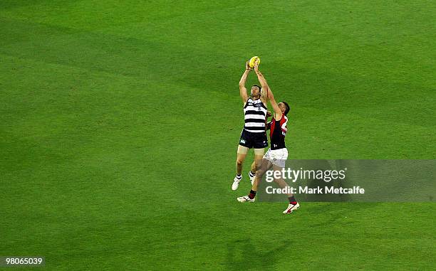 Cameron Mooney of the Cats takes a mark over Cale Hooker of the Bombers during the round one AFL match between the Geelong Cats and the Essendon...