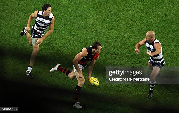 Jobe Watson of the Bombers gains posession over Paul Chapman and Harry Taylor of the Cats during the round one AFL match between the Geelong Cats and...