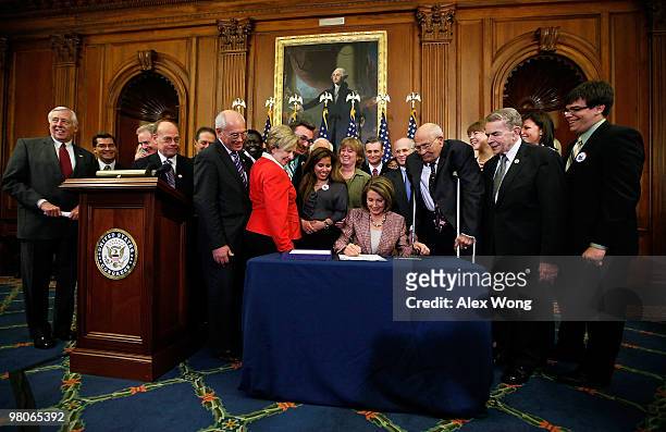 Surrounded by Democratic House members and other guests, U.S. Speaker of the House Rep. Nancy Pelosi signs the revised Health Care and Education...