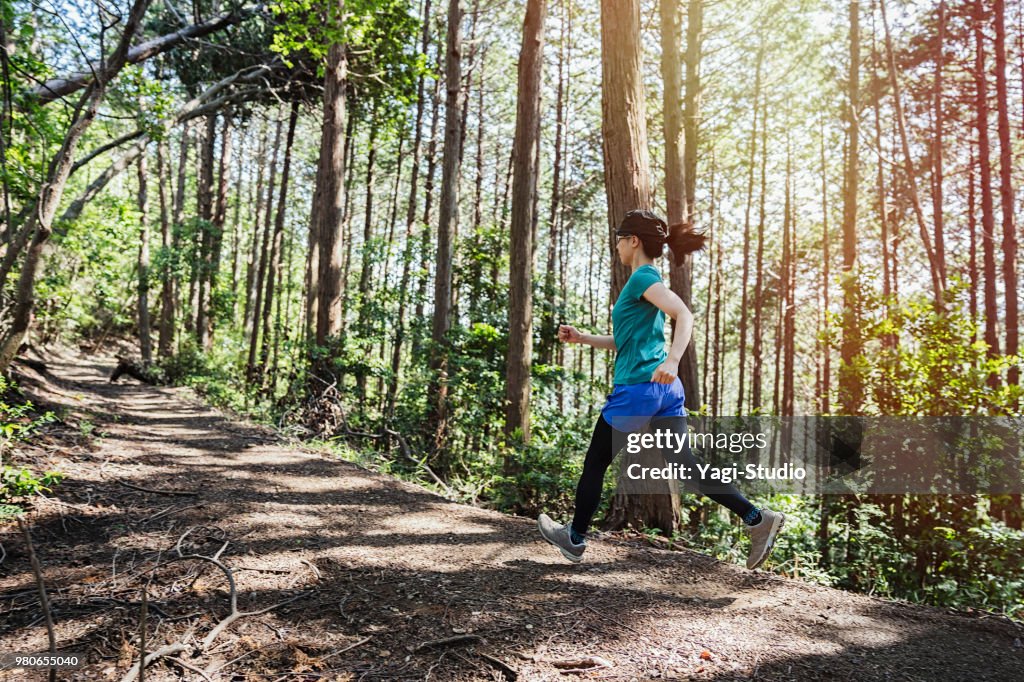 Fitness female trail runner running on a mountain path