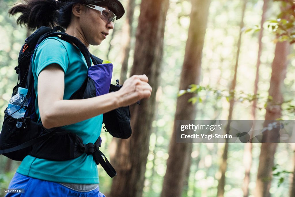 Fitness female trail runner running on a mountain path