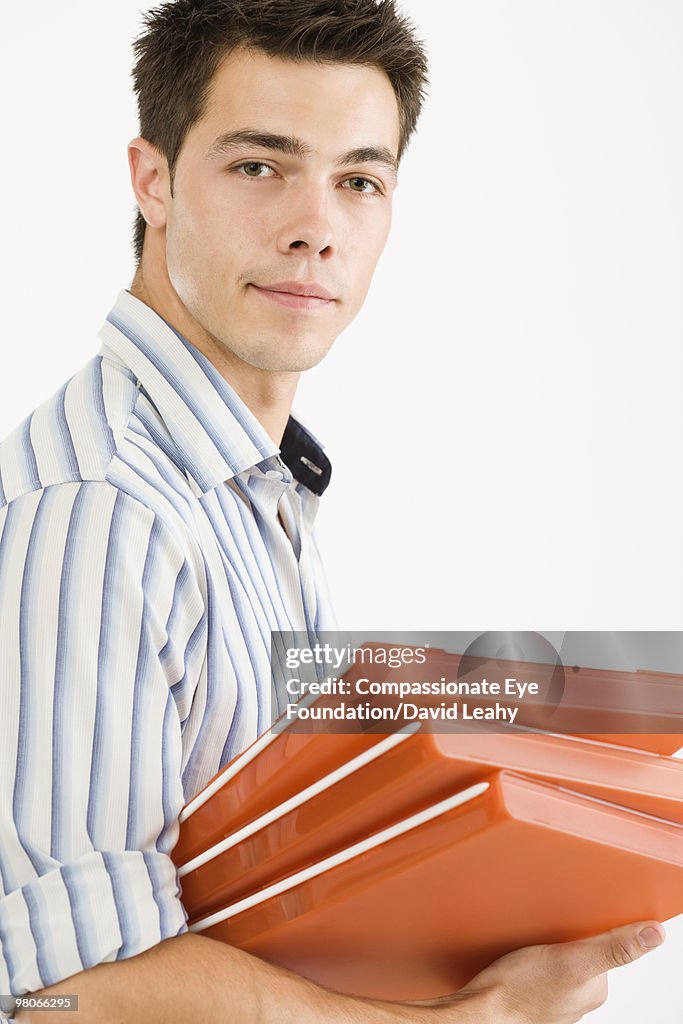 Man Using File Portrait Of Man Holding A Stack Of Orange Files High-Res Stock Photo ...