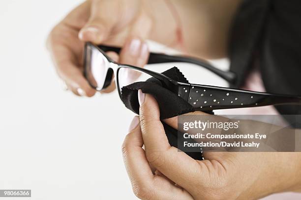 eye glasses being cleaned by woman's hands - david leahy studio stock pictures, royalty-free photos & images