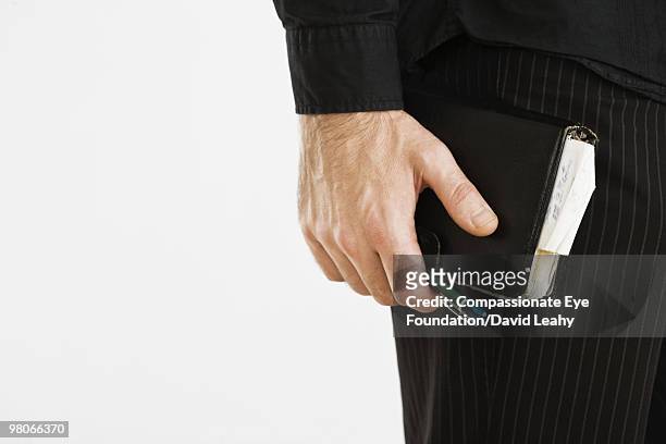 man's hand holding an organizer and a pen - david leahy studio stock pictures, royalty-free photos & images