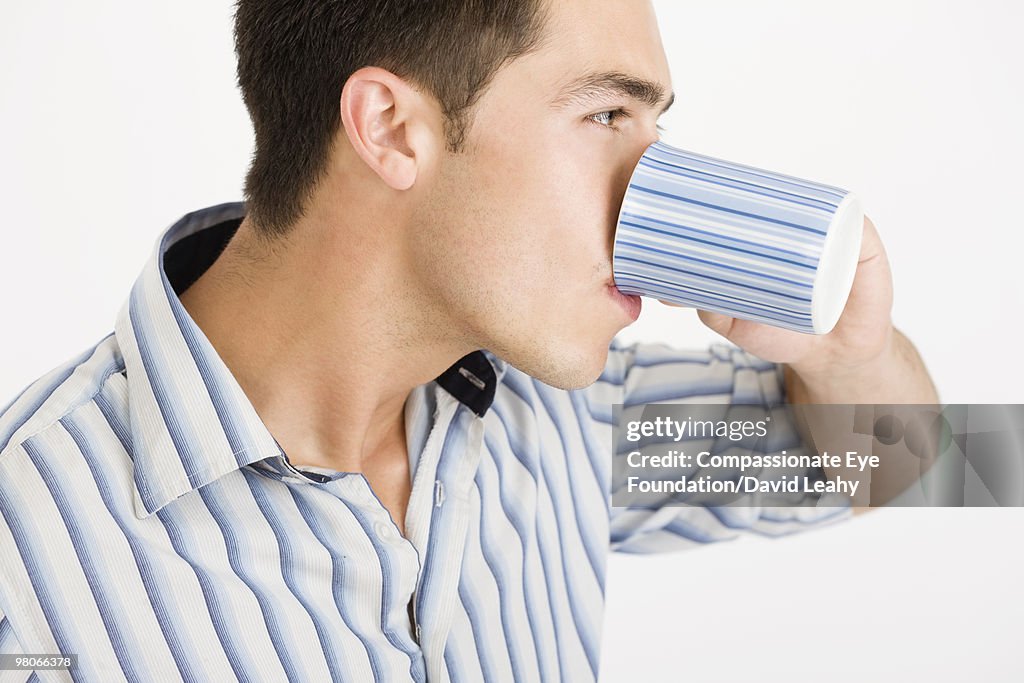 Man drinking out of striped mug