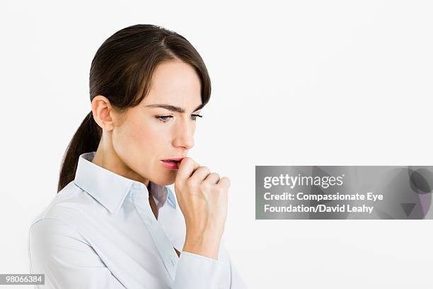 portrait of woman with her hand at her mouth - david leahy studio stock pictures, royalty-free photos & images