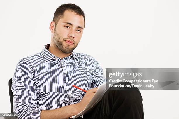 portrait of man sitting and writing - david leahy studio stock pictures, royalty-free photos & images