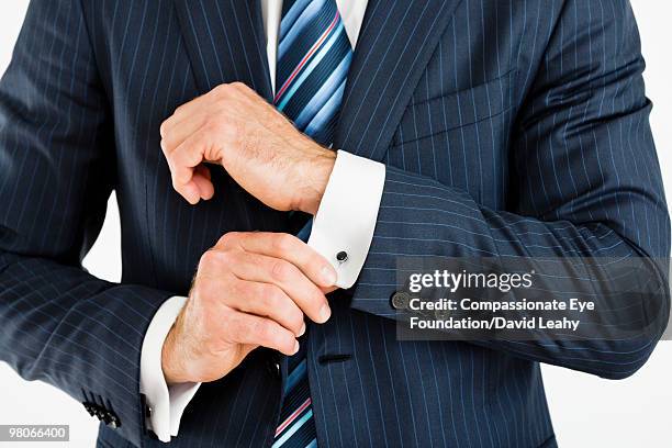 man adjusting cuff links on his suit - cufflinks stock-fotos und bilder