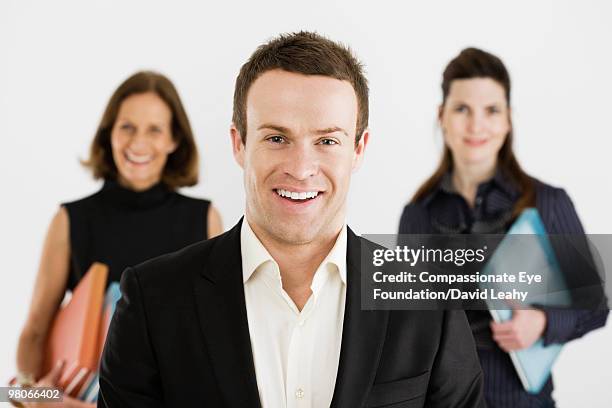 smiling man infront of two smiling women - david leahy studio stock pictures, royalty-free photos & images