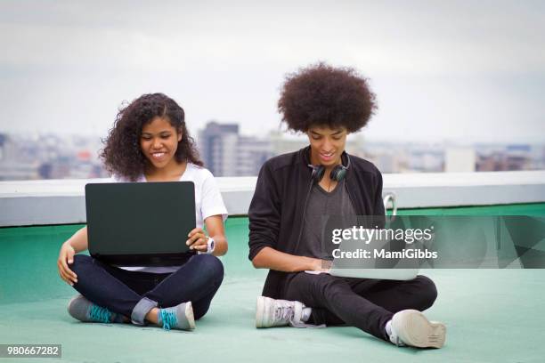 young couple are working on a computer on the roof - mamigibbs stock pictures, royalty-free photos & images