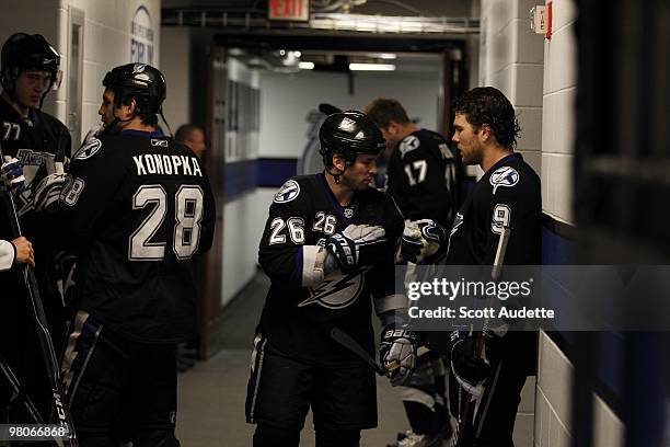Martin St. Louis of the Tampa Bay Lightning talks with teammate Steve Downie before the start of the game against the Carolina Hurricanes at the St....