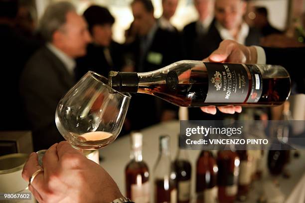 Picture taken on March 24, 2010 shows a man with a glass of Armagnac during a ceremony in Rome after a copy of the 1531's Armagnac original product...