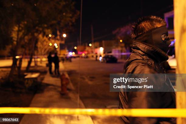 Police stand near the car where the body of a 13 year old boy lies dead, one of numerous murders over a 24 hour period, on March 25, 2010 in Juarez,...