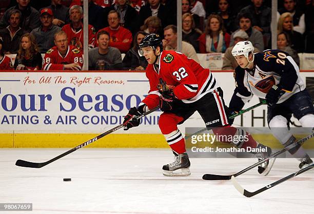 Kris Versteeg of the Chicago Blackhawks looks to pass under pressure from Colby Armstrong of the Atlanta Thrashers at the United Center on February...