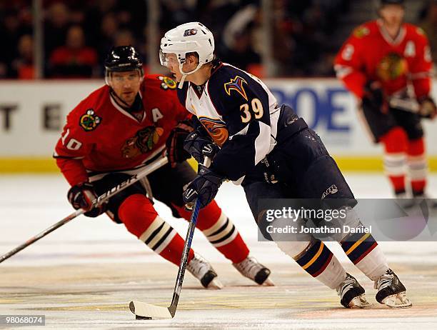 Tobias Enstrom of the Atlanta Thrashers controls the puck in front of Patrick Sharp of the Chicago Blackhawks at the United Center on February 13,...