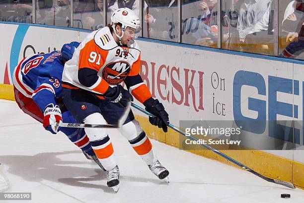John Tavares the New York Islanders skates with the puck under pressure by Marc Staal of the New York Rangers in the second period on March 24, 2010...