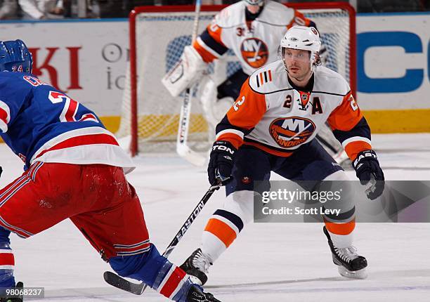 Mark Streit of the New York Islanders skates against Ryan Callahan of the New York Rangers in the first period on March 24, 2010 at Madison Square...