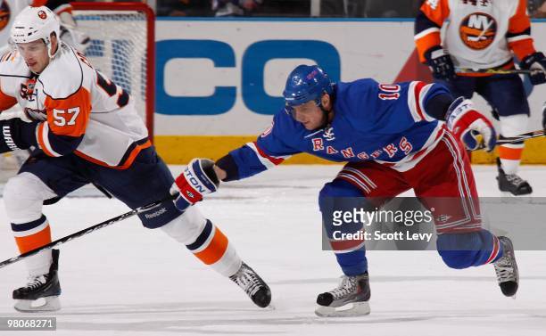 Marian Gaborik of the New York Rangers reaches for the puck against Blake Comeau of the New York Islanders on March 24, 2010 at Madison Square Garden...