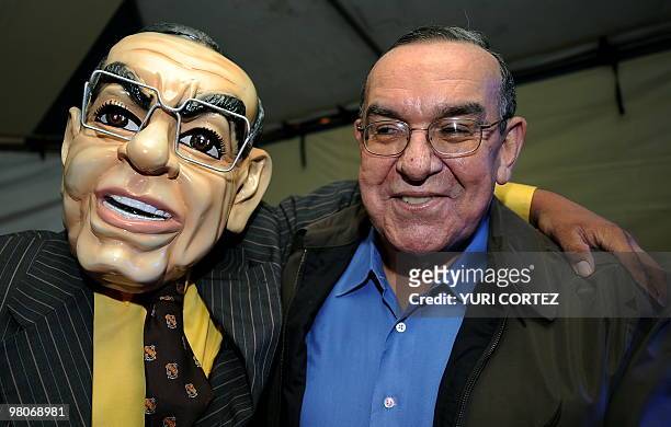 Presidency Minister Rodrigo Arias poses for a picture with a man wearing a mask of his face, during the opening ceremony of the VIII National...