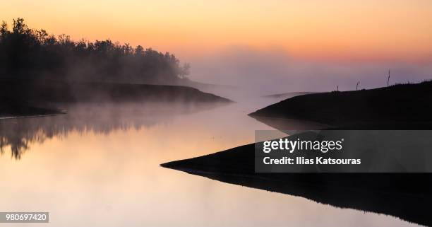 a foggy morning by the lake - katsouras stock-fotos und bilder