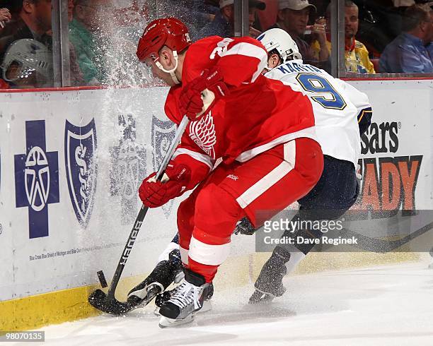 Brian Rafalski of the Detroit Red Wings battles along the boards for the puck with Paul Kariya of the St. Louis Blues during an NHL game at Joe Louis...