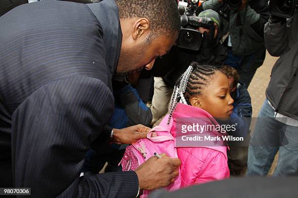 Player Gilbert Arenas of the Washington Wizards autographs the book bag of 7-year-old Meagan Tutt before he walks into the District of Columbia Court...