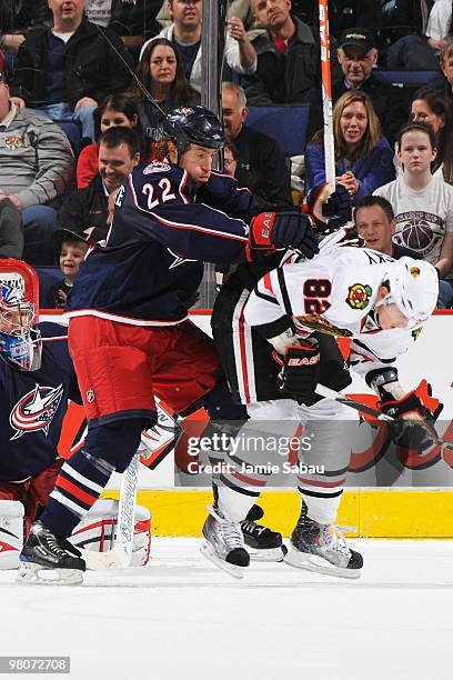 Defenseman Mike Commodore of the Columbus Blue Jackets checks forward Tomas Kopecky of the Chicago Blackhawks on March 25, 2010 at Nationwide Arena...