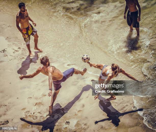 gruppe von brasilianischen jugendlichen fußball spielen am strand der copacabana an einem heißen sommertag - grafissimo stock-fotos und bilder