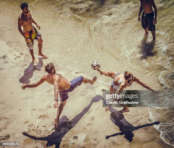 group of young brazilian people playing soccer on copacabana beach on a hot summer day - grafissimo stock pictures, royalty-free photos & images