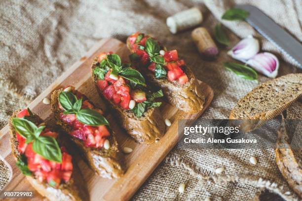 view of bruschetta on chopping board - bruschetta stock-fotos und bilder