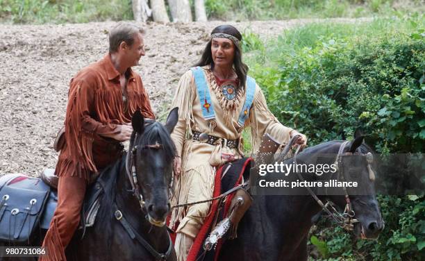 June 2018, Germany, Lennestadt: Jean-Marc Birkholz as 'Winnetou' and Kai Noll as 'Old Shatterhand' riding horses on the outdoor stage at a press...