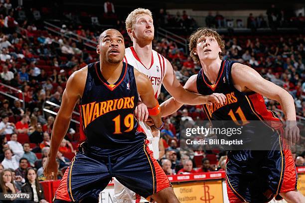 Devean George and Coby Karl of the Golden State Warriors rebound against Chase Budinger of the Houston Rockets during the game on February 2, 2010 at...