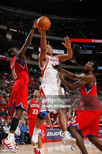 Chuck Hayes of the Houston Rockets lays up a shot against Jrue Holiday and Samuel Dalembert of the Philadelphia 76ers during the game on February 6,...