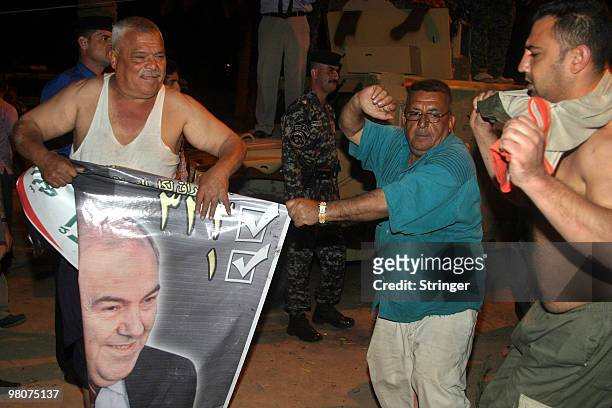 Supporters of former Iraqi Prime Minister Iyad Allawi celebrate after the announcement of the elections results which showed that a coalition led by...