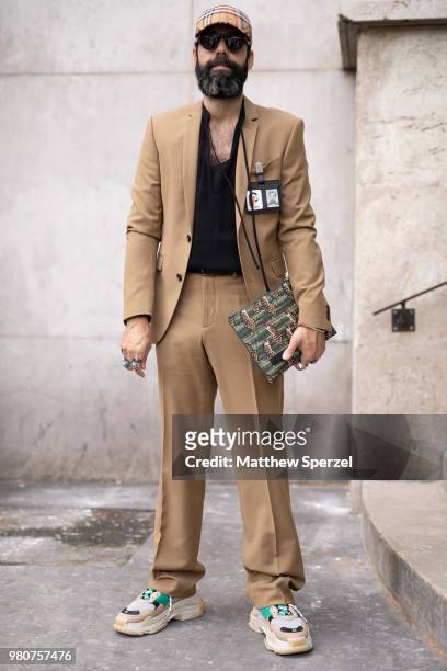 Guest is seen on the street during Paris Men's Fashion Week S/S 2019 wearing a tan suit with black shirt and Balenciaga sneakers on June 21, 2018 in...
