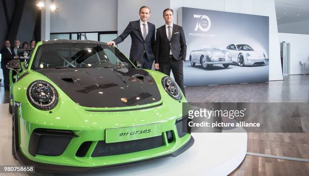 March 2018, Germany, Stuttgart: Oliver Blume , CEO of Porsche AG, and Lutz Meschke, deputy chairman, stand next to a Porsche car of the model 911 GT3...