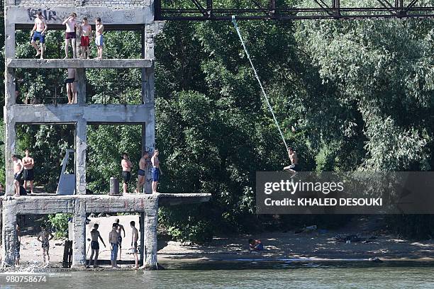 Picture taken on June 21, 2018 shows young men cooling off on the bank of the Don River in Rostov on-Don, June 18, 2018 during the Russia 2018 World...