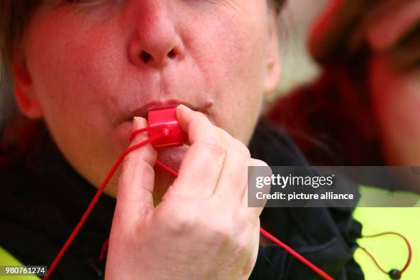 March 2018, Germany, Gera: Ramona Teske, public service employee of Gera's city administration, blows a whistle during a warning strike organised by...